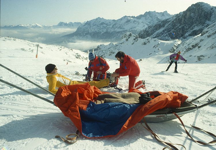 Vorbereitung eines verletzten Skifahrers für den Transport mit einem Akja in den 1990er Jahren 