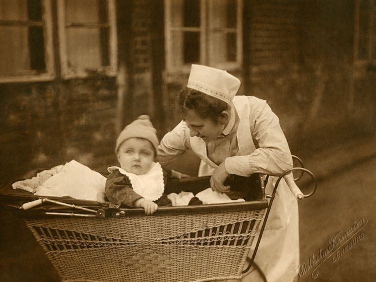 Eine Helferin des Vaterländischen Frauenvereins Kreis Lüneburg kümmert sich um ein Kleinkind (DRK)